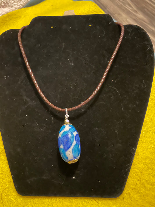 Colgante de cuero trenzado color marron con dije de porcelana pintada a mano